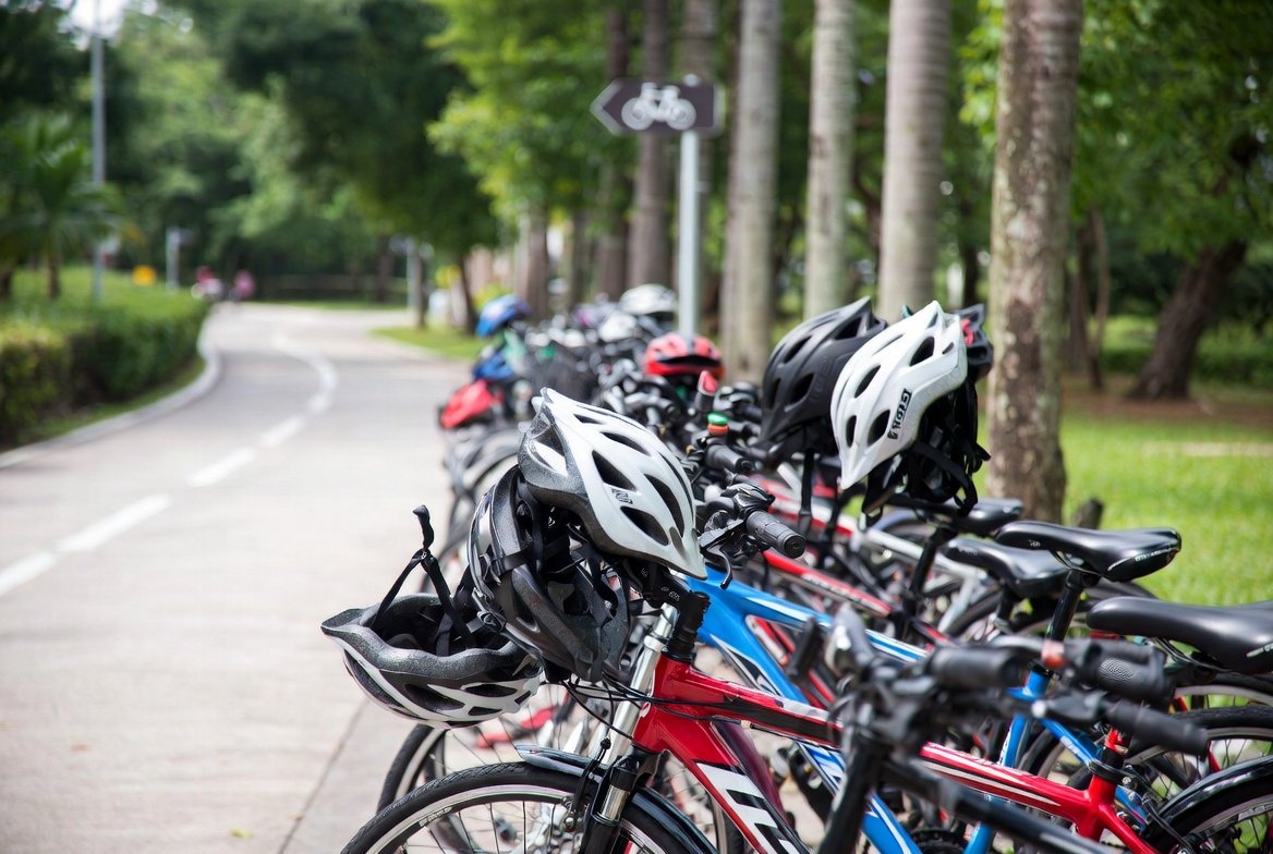 Bicycles and safety helmets lined up along a Singapore park connector.